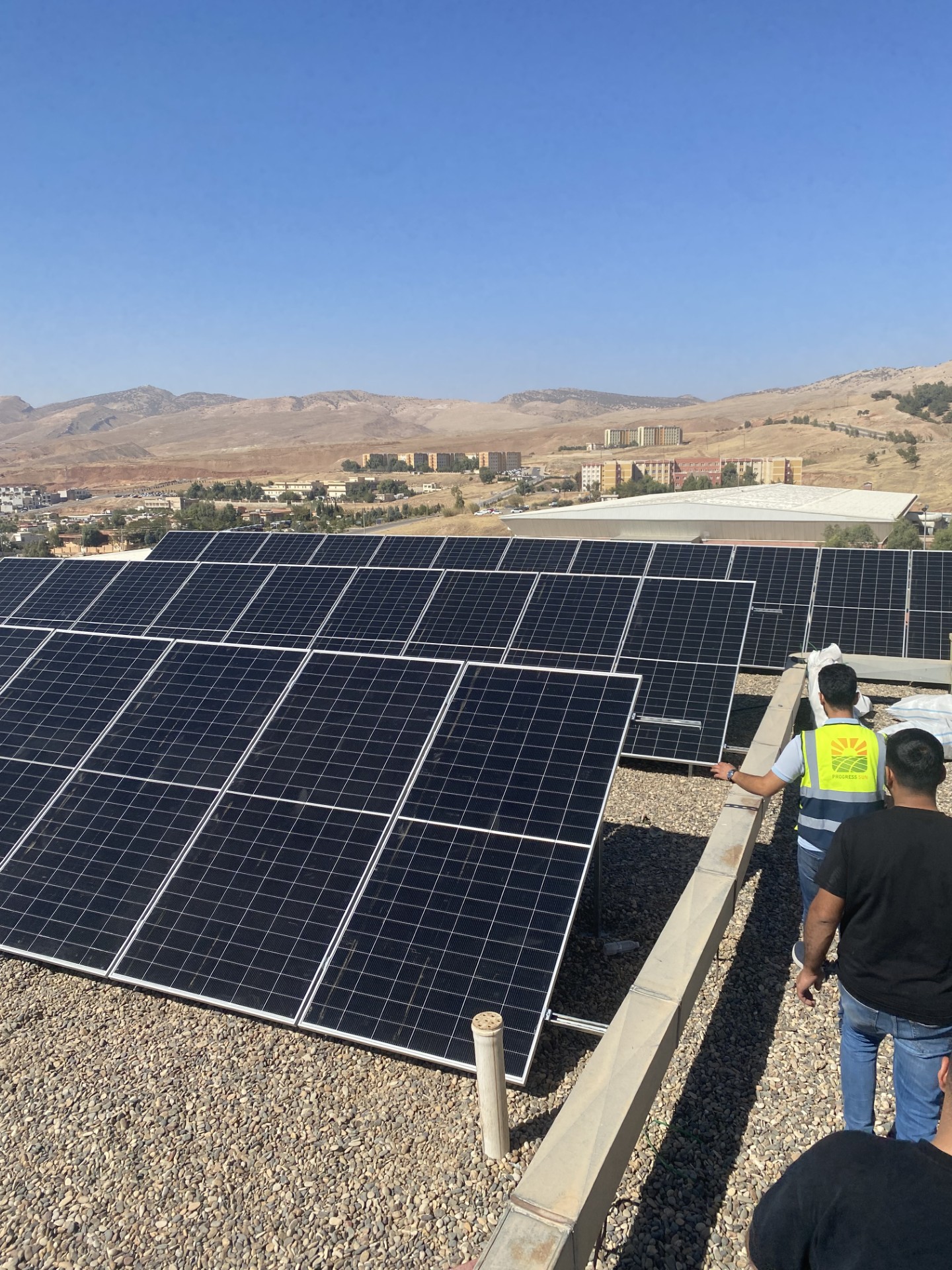 Koya University rooftop solar panels with Progress Sun site team